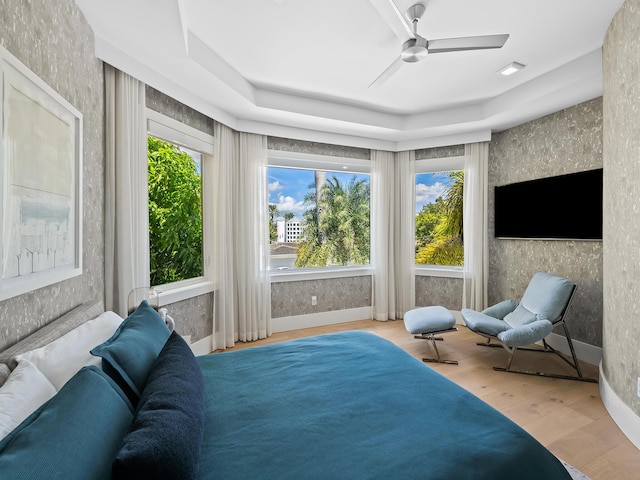 bedroom featuring wallpapered walls, ceiling fan, baseboards, and wood finished floors