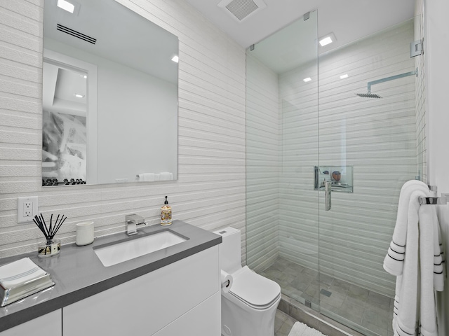 bathroom featuring toilet, vanity, a shower stall, and visible vents