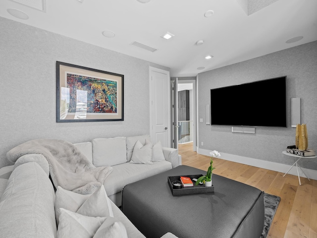 living area with visible vents, baseboards, and hardwood / wood-style flooring