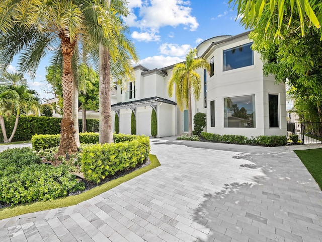 view of front of home featuring decorative driveway, an attached garage, and stucco siding