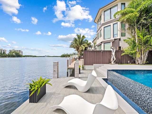 dock area with a water view, fence, and a fenced in pool