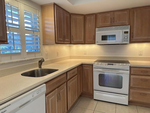 kitchen with white appliances, light countertops, and a sink