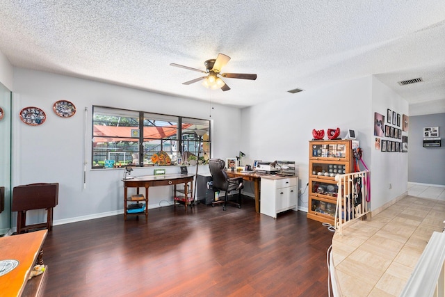 home office with dark wood-type flooring, a textured ceiling, and ceiling fan