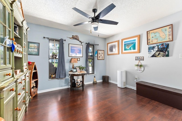 misc room with ceiling fan, dark hardwood / wood-style floors, and a textured ceiling