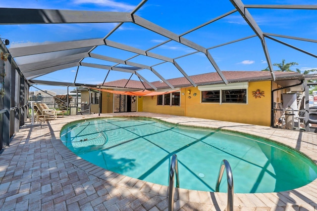 view of swimming pool featuring a patio area and glass enclosure