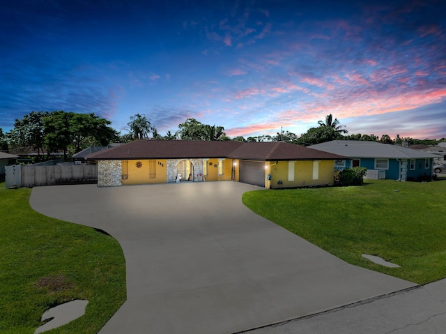 single story home with a garage and a lawn