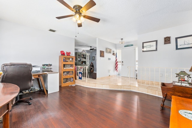 office area featuring ceiling fan, dark hardwood / wood-style flooring, and a textured ceiling