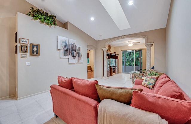 tiled living room featuring vaulted ceiling, ornate columns, and ceiling fan