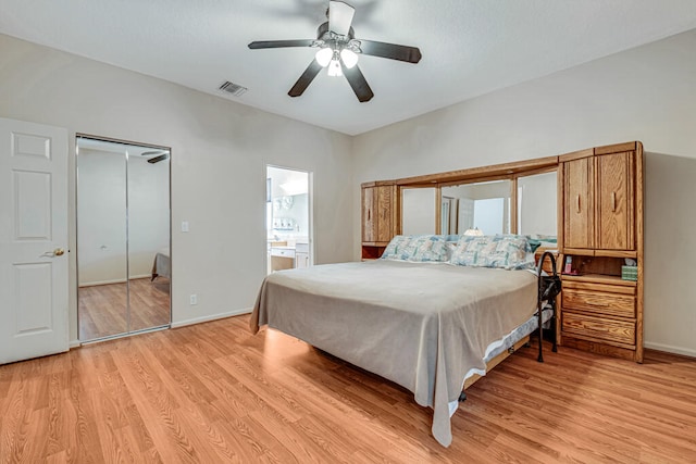 bedroom featuring light hardwood / wood-style flooring, ensuite bathroom, and ceiling fan