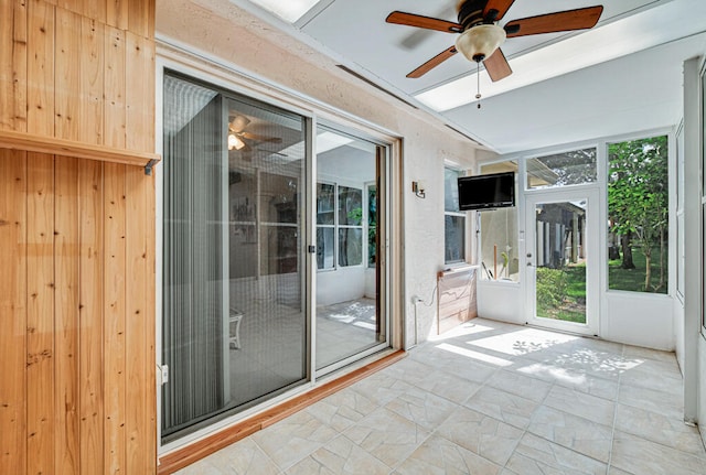 unfurnished sunroom featuring ceiling fan