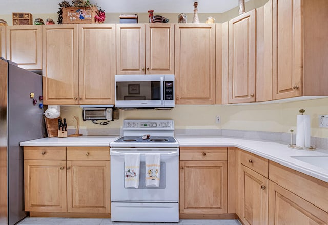 kitchen with appliances with stainless steel finishes and light brown cabinets