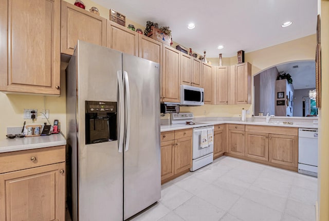 kitchen with sink, light brown cabinetry, and white appliances