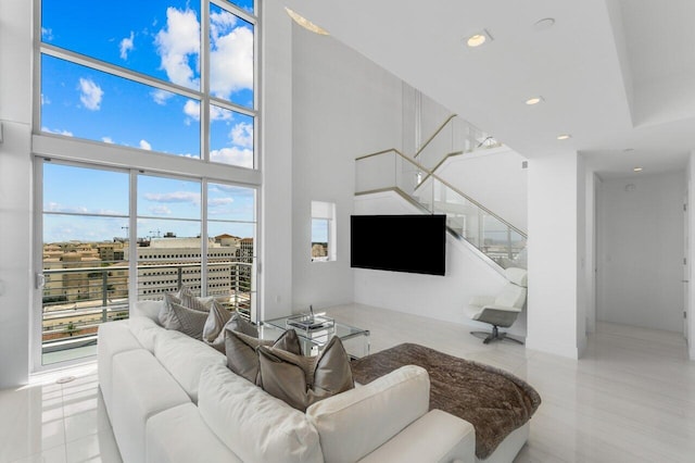 living room featuring light tile patterned floors, a wealth of natural light, and a towering ceiling