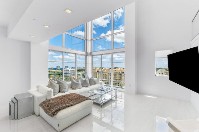 living room featuring a towering ceiling, recessed lighting, and light tile patterned flooring