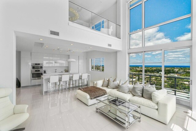 living room featuring a towering ceiling and visible vents