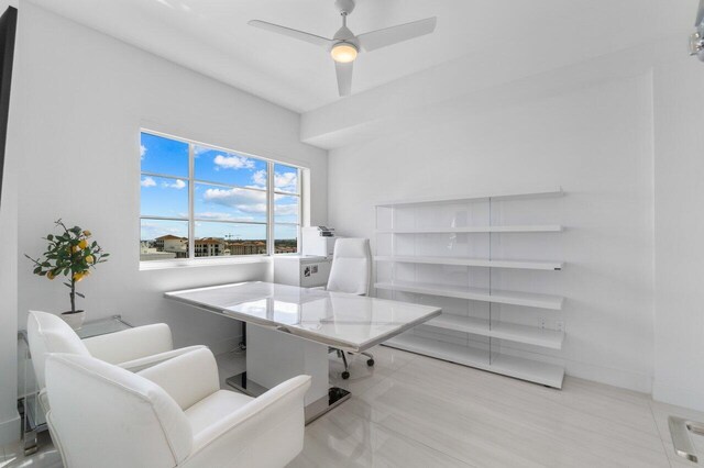 home office with a ceiling fan and tile patterned floors