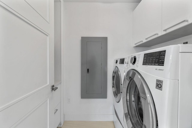 clothes washing area with cabinet space, light wood finished floors, electric panel, baseboards, and separate washer and dryer