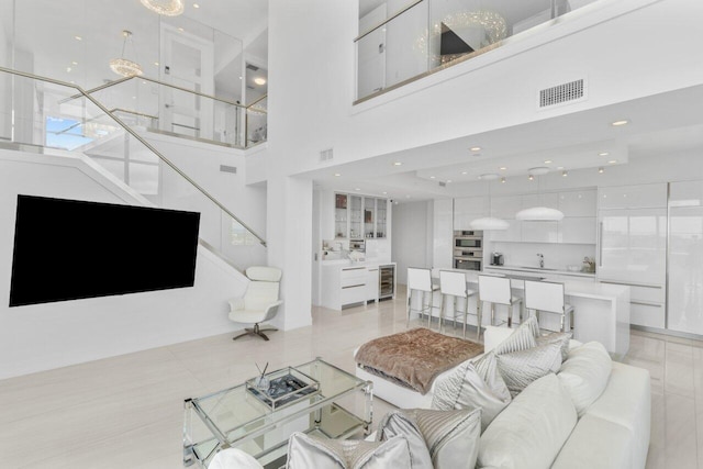 living room with a towering ceiling and light tile patterned floors