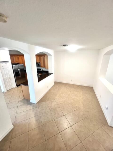 interior space featuring appliances with stainless steel finishes and light tile patterned floors