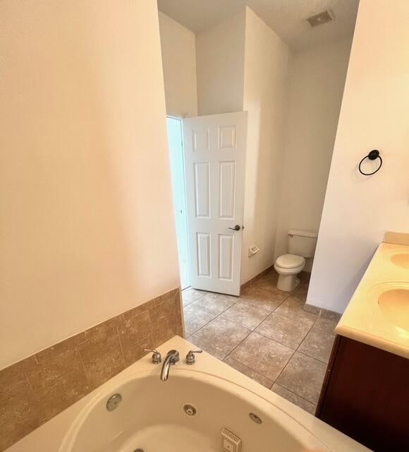 bathroom with vanity, toilet, a bathtub, and tile patterned floors