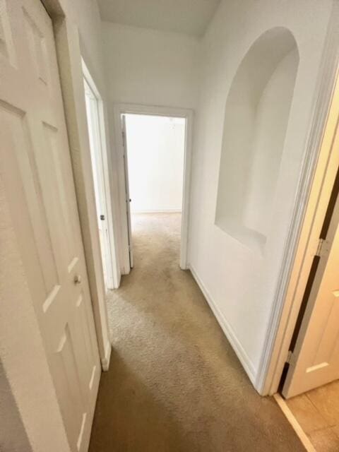 hallway featuring light colored carpet