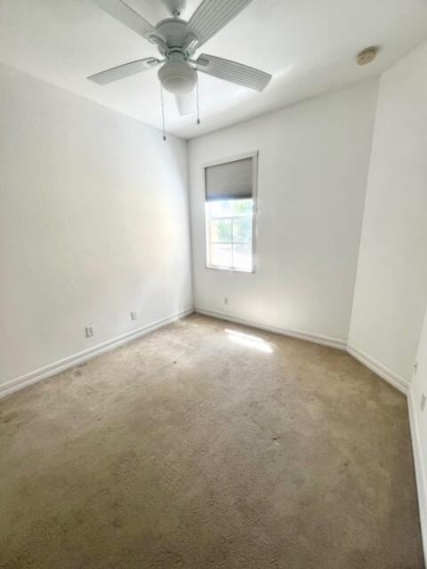 carpeted empty room featuring ceiling fan