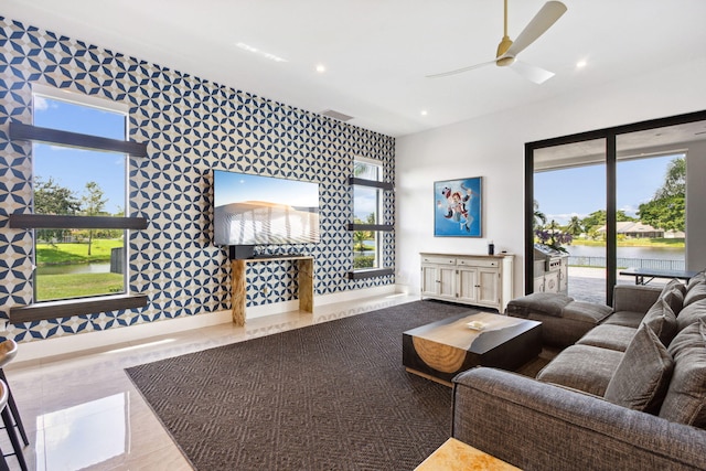 living room with a water view and ceiling fan