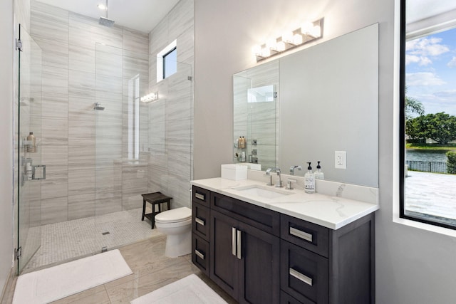 bathroom featuring vanity, toilet, and a shower with shower door