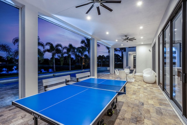 recreation room with floor to ceiling windows and ceiling fan