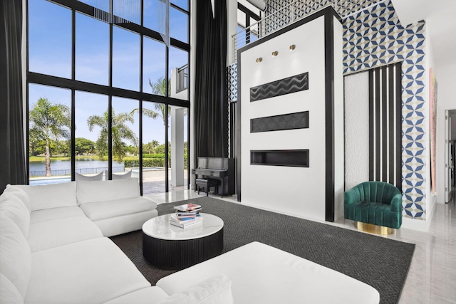 living room featuring a high ceiling, a water view, and floor to ceiling windows