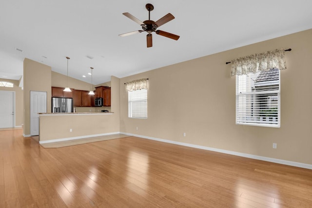 2609 SW Gallery Cir, Palm City, FL 34990 - unfurnished living room with vaulted ceiling, light wood-style floors, a ceiling fan, and baseboards