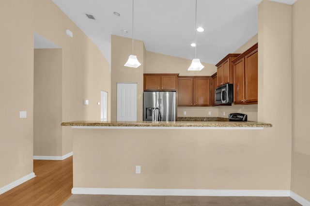 2609 SW Gallery Cir, Palm City, FL 34990 - kitchen with appliances with stainless steel finishes, brown cabinets, hanging light fixtures, a peninsula, and lofted ceiling