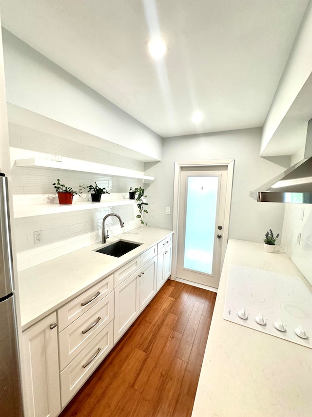 kitchen featuring backsplash, sink, white electric stovetop, dark wood-type flooring, and white cabinets