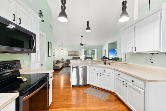 kitchen with light hardwood / wood-style flooring, hanging light fixtures, vaulted ceiling, and appliances with stainless steel finishes