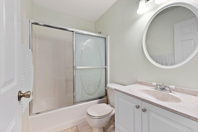 full bathroom featuring combined bath / shower with glass door, tile patterned floors, a textured ceiling, toilet, and vanity