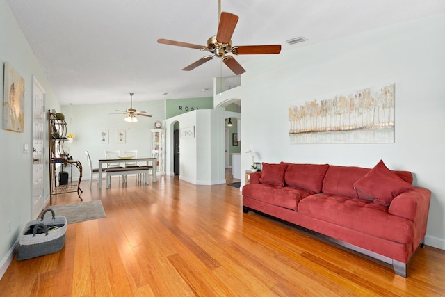 living room featuring hardwood / wood-style floors, ceiling fan, and vaulted ceiling