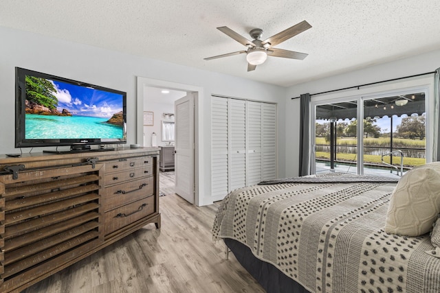 bedroom with light hardwood / wood-style floors, a textured ceiling, access to exterior, a closet, and ceiling fan