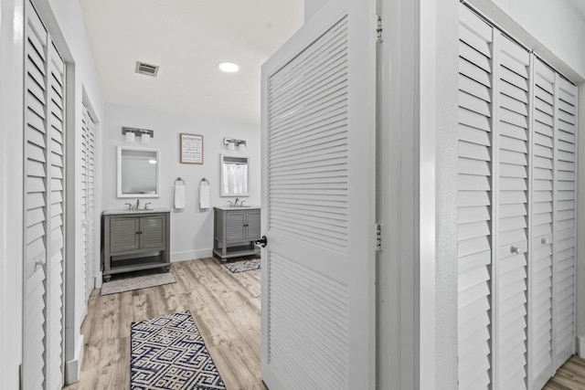 hallway with sink and light hardwood / wood-style floors