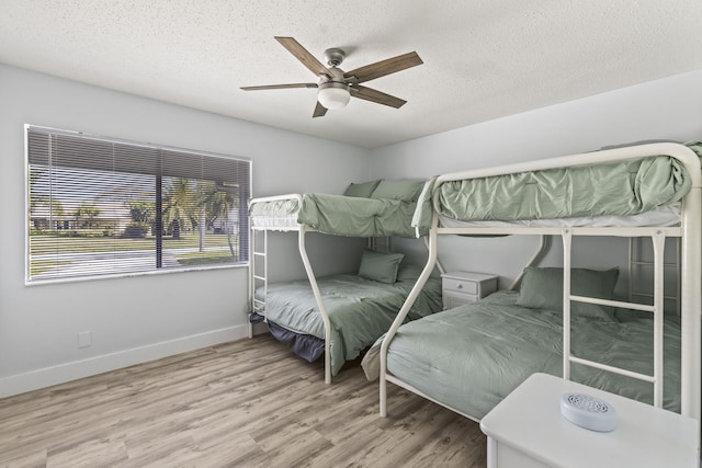 bedroom featuring light wood-type flooring, ceiling fan, and a textured ceiling