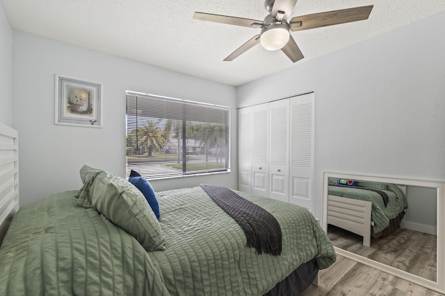 bedroom featuring a textured ceiling, a closet, ceiling fan, and hardwood / wood-style floors