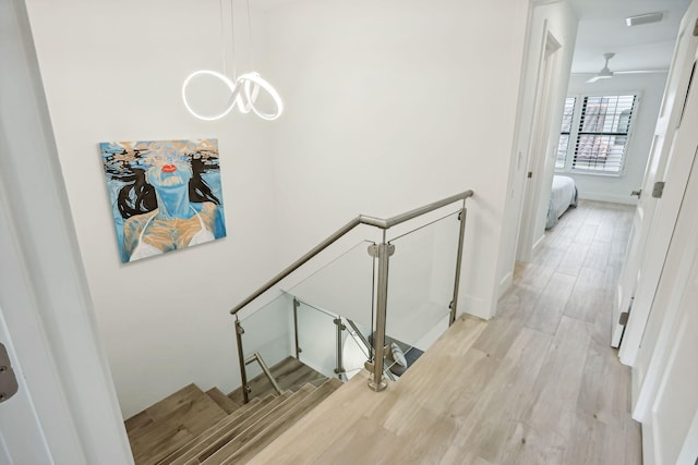 stairs with ceiling fan and hardwood / wood-style floors