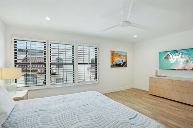 bedroom with ceiling fan, multiple windows, and light hardwood / wood-style floors