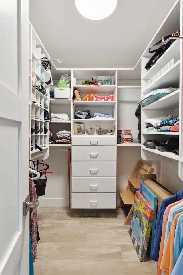 spacious closet with light hardwood / wood-style flooring