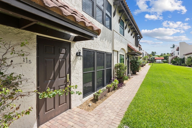 property entrance featuring a lawn