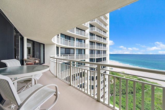 balcony featuring a water view and a view of the beach