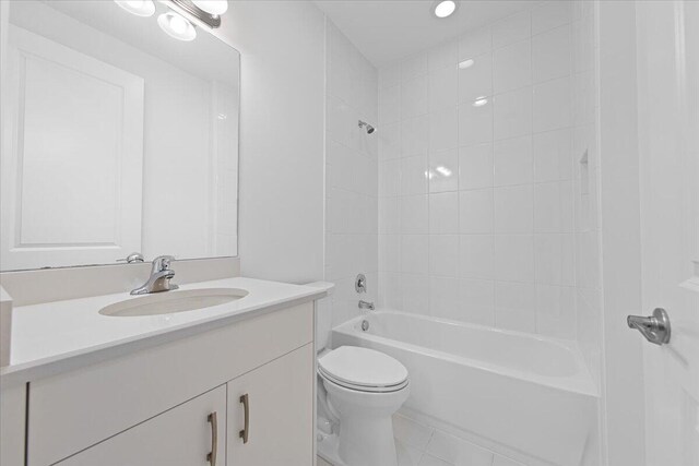 full bathroom featuring tile patterned flooring, vanity, toilet, and tiled shower / bath