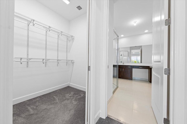 spacious closet featuring light colored carpet