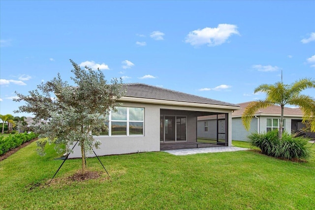 rear view of house with a lawn and a patio