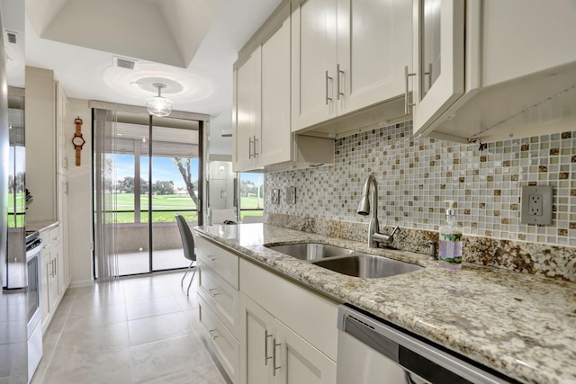 kitchen with sink, decorative backsplash, appliances with stainless steel finishes, and light stone counters