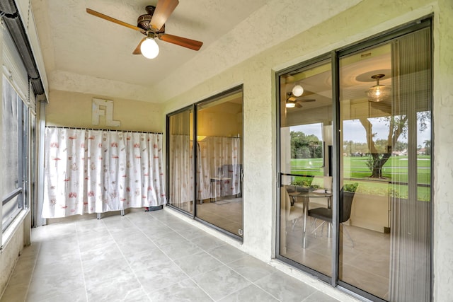 unfurnished sunroom featuring ceiling fan